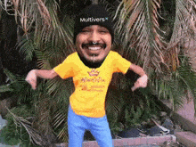 a man wearing a yellow t-shirt with a crown on it is dancing in front of a palm tree