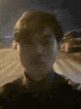 a man is walking down a street at night and making a funny face .