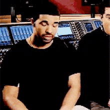 a man is sitting in front of a mixer in a recording studio