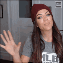 a woman wearing a beanie and a t-shirt that says olb
