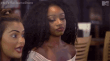 two women are standing next to each other in a restaurant and one of them is looking at the camera .