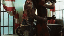a man and a woman are dancing in a living room with a motorcycle in the background .