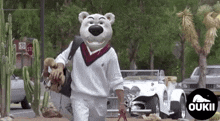a man in a bear mask is walking down the street holding a dog .