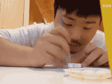 a man sitting at a table with chinese writing on the bottom left