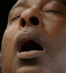 a man with his eyes closed and his mouth open
