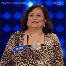 a woman in a leopard print top has a name tag that says rekha