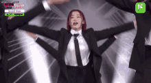 a woman in a suit and tie is performing on a stage that says kcon 2022