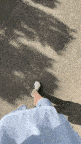 a person wearing a blue dress and white sneakers is walking on a street