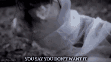 a woman in a white dress is laying on the ground with the words `` you say you don 't want it '' written above her .