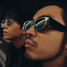a close up of a man wearing sunglasses looking up