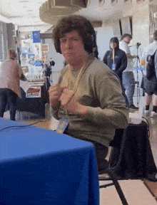 a man wearing headphones sits at a table with a name tag that says ' chris ' on it