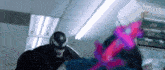 venom is fighting spider-man in a store in a movie .