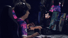 a man wearing headphones and a shirt that says king sits in front of a computer