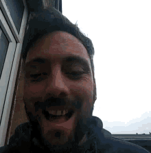 a man with a beard is smiling with his eyes closed