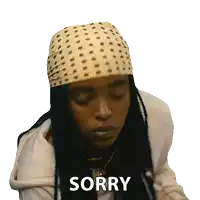 a woman with dreadlocks wearing a bandana and a sticker that says sorry