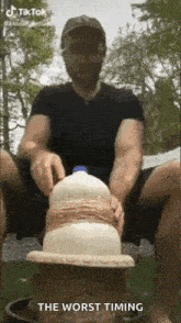 a man is sitting on a stool with a bottle of milk in his hands .