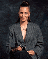 a woman wearing a striped jacket is holding a box