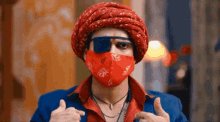 a man wearing a turban and sunglasses is wearing a red mask .
