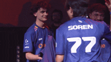 a man wearing a blue shirt with the number 77 on the back