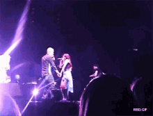 a man and a woman singing on a stage with rbd.gif in the corner