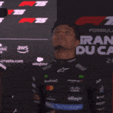a man standing in front of a sign that says " formula 1 "