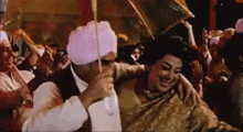 a man is holding an umbrella over a woman in a crowd .