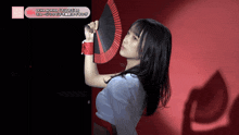 a woman holding a fan in front of a sign that says ocha normal on it