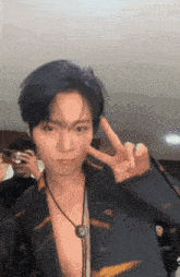 a young man without a shirt is giving a peace sign