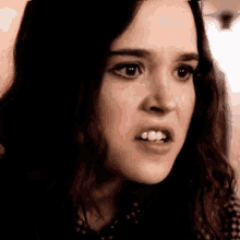 a close up of a woman making an angry face