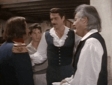 a group of men are standing in a room and talking