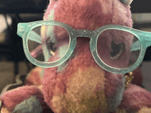 a stuffed animal is wearing glasses and a necklace
