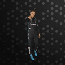 a man in a petronas suit is pointing
