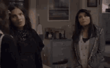 a group of women are standing next to each other in a living room .