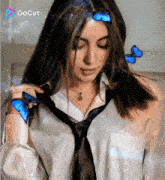 a woman wearing a tie and a necklace is surrounded by blue butterflies and a gocut logo