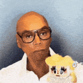 a man wearing glasses is holding a stuffed animal