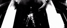 a black and white photo of a person 's hands reaching out towards a skeleton
