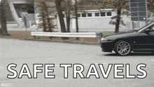 a black car is driving down a street with the words safe travels written on the bottom
