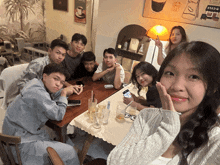 a group of people sitting around a table with a sign on the wall that says ' cafe '