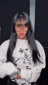 a woman wearing glasses and a white sweatshirt with a face on it