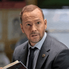 a man in a suit and tie is holding a book that says ' insight ' on it