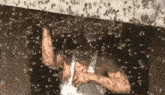 a woman in a white tank top is surrounded by bees