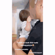 a man is holding a baby in his arms and the baby is eating pizza