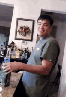 a man in a green shirt is standing in front of a picture