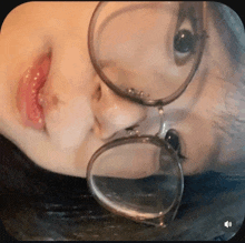 a close up of a person 's face with glasses on their face