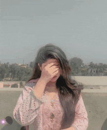 a woman covering her face with a pink heart shaped object