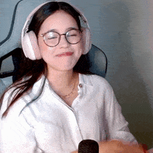 a woman wearing headphones and glasses is making a funny face