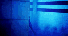 a person is swimming in a pool in a dark room with blue lights .