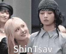 a group of women are standing next to each other and one of them is wearing a beanie .