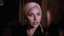lady gaga is wearing a black jacket and earrings and is holding a knife in her mouth