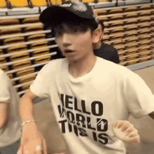 a man wearing a hat and a white shirt that says hello world this is